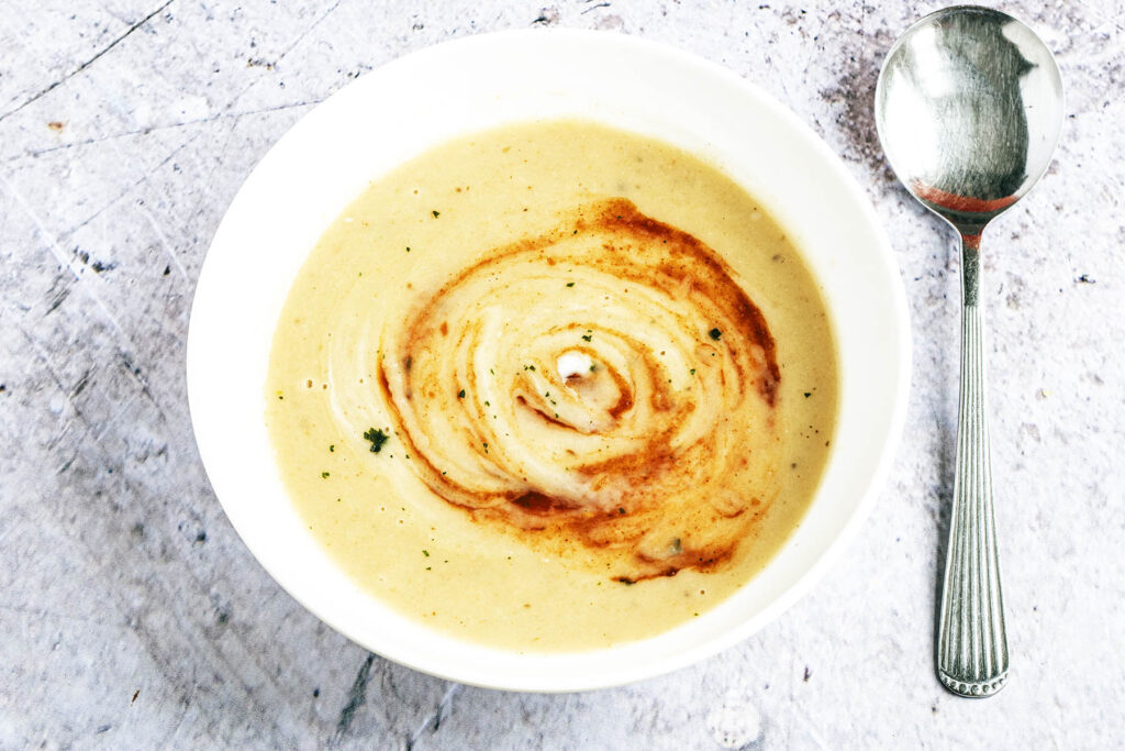 Jerusalem artichoke and celeriac soup in white bowl