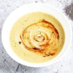 Jerusalem artichoke and celeriac soup in white bowl