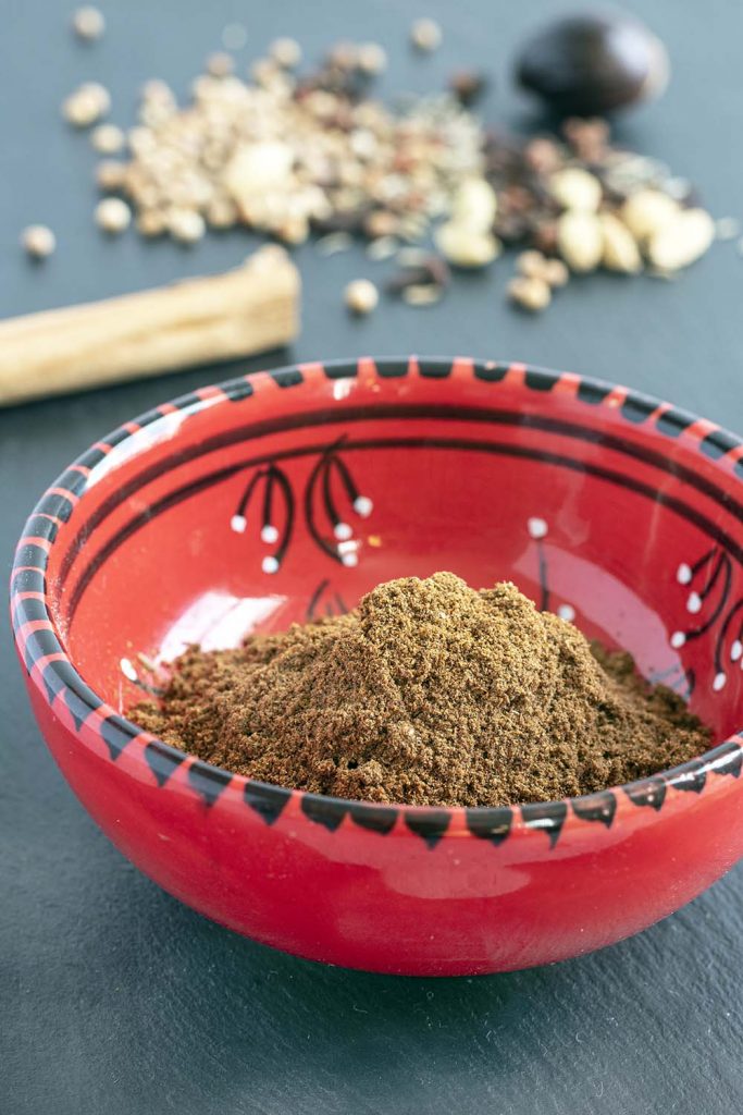 Sri Lankan curry powder in bowl with whole spices in background