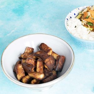 marinated tofu in bowl with stir fry and veg in background