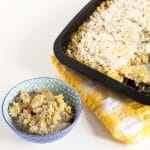 vegan butternut squash macaroni cheese in baking dish with a small portion in blue and white bowl