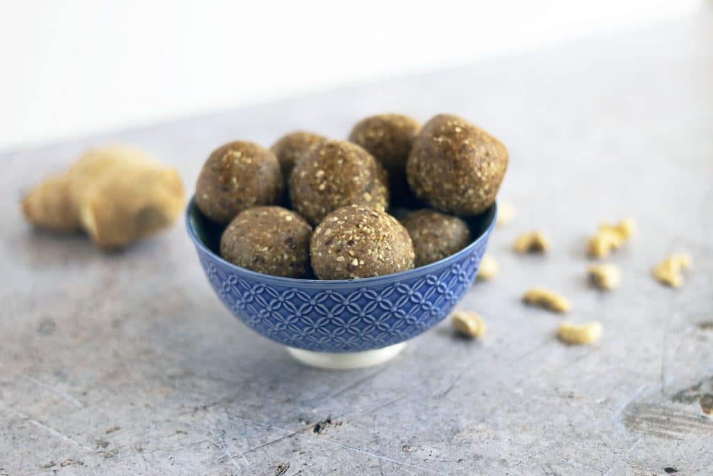 ginger energy balls in bowl with ginger and cashews