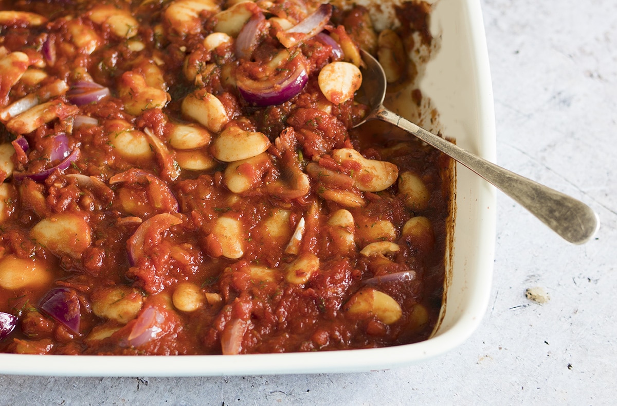 Greek-style baked beans with tomato sauce and dill in roasting tin