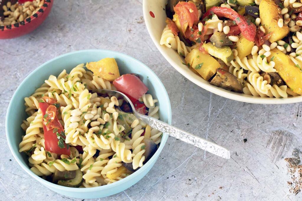 bowls of pasta, vegetables and pine nuts