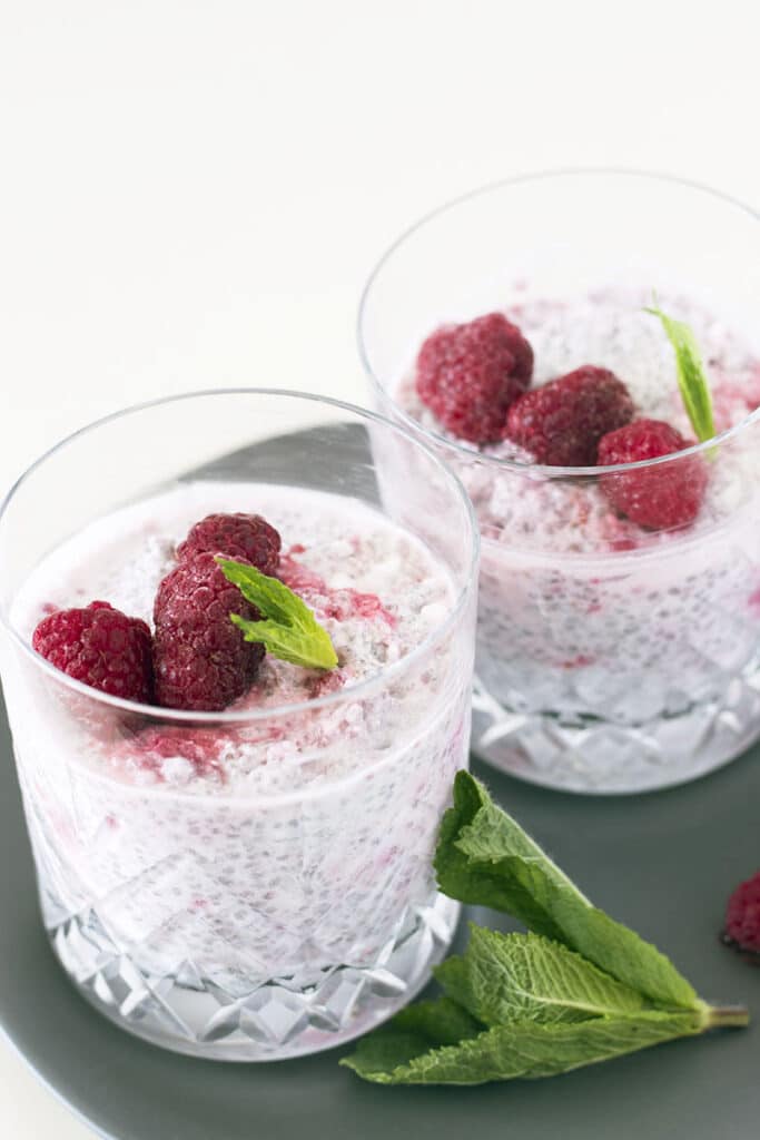 coconut chia pudding with raspberries in glasses
