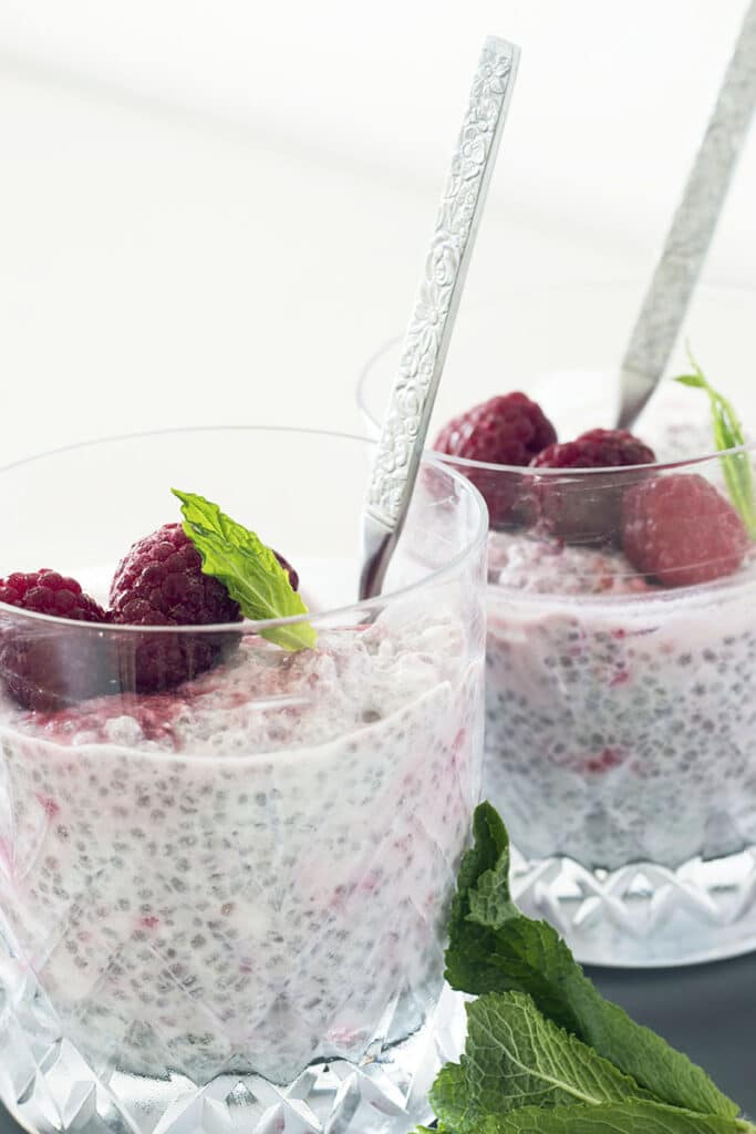 coconut chia pudding with raspberries in glasses