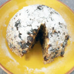 vegan christmas pudding on yellow plate