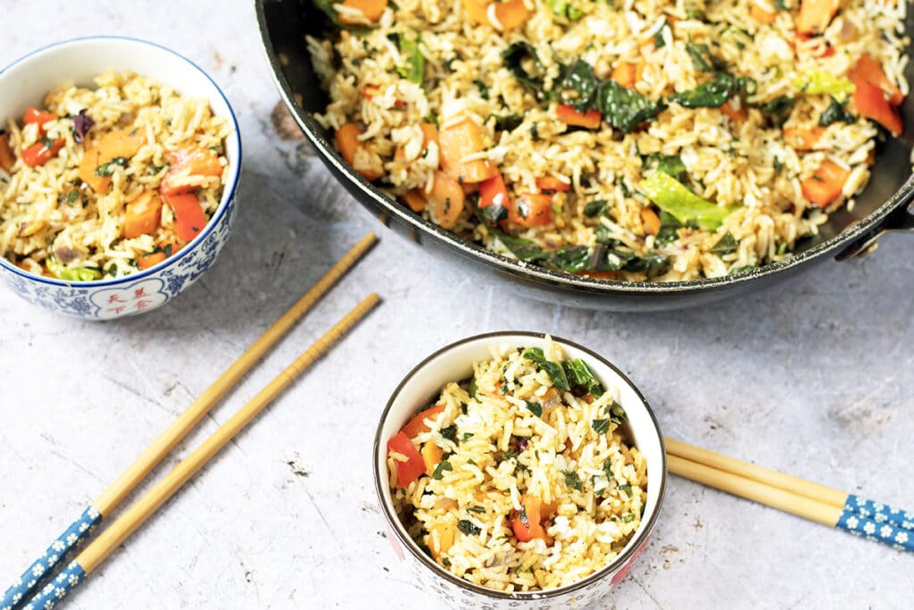 thai basil fried rice in wok and bowls