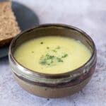 leek and parsnip soup in bowl with bread in background