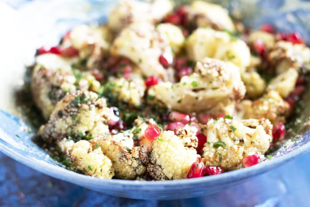roasted cauliflower and pomegranate salad in blue bowl
