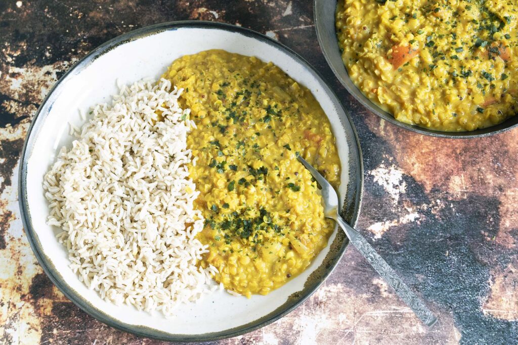 lentil dal with rice on plate and in black pot
