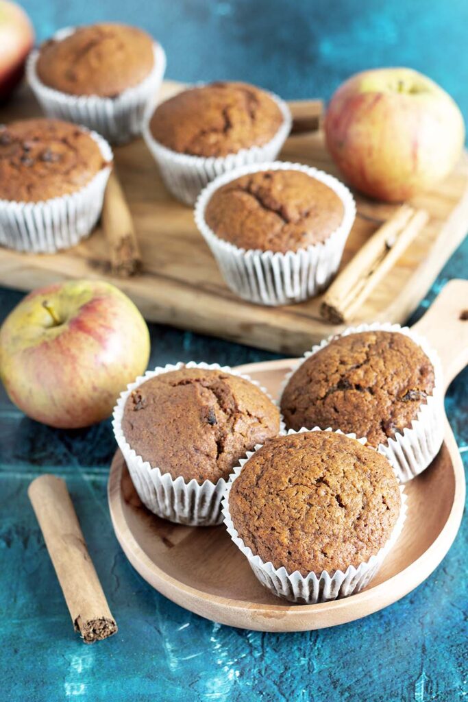 vegan apple muffins on board with apples and cinnamon sticks