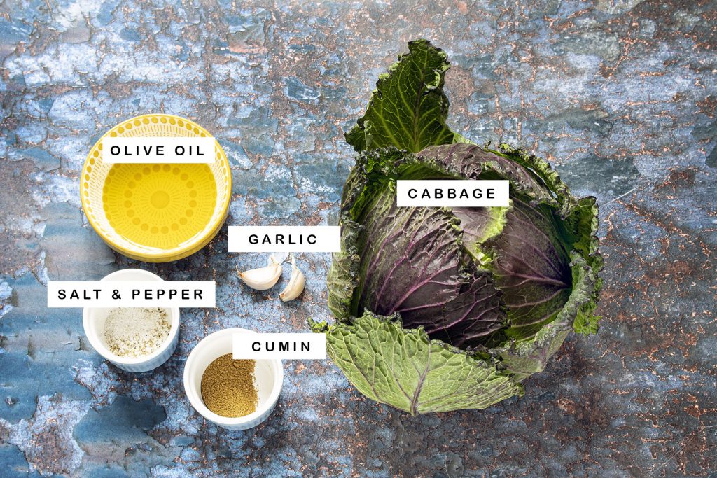 cabbage, oil, cumin, garlic, salt and pepper on blue background