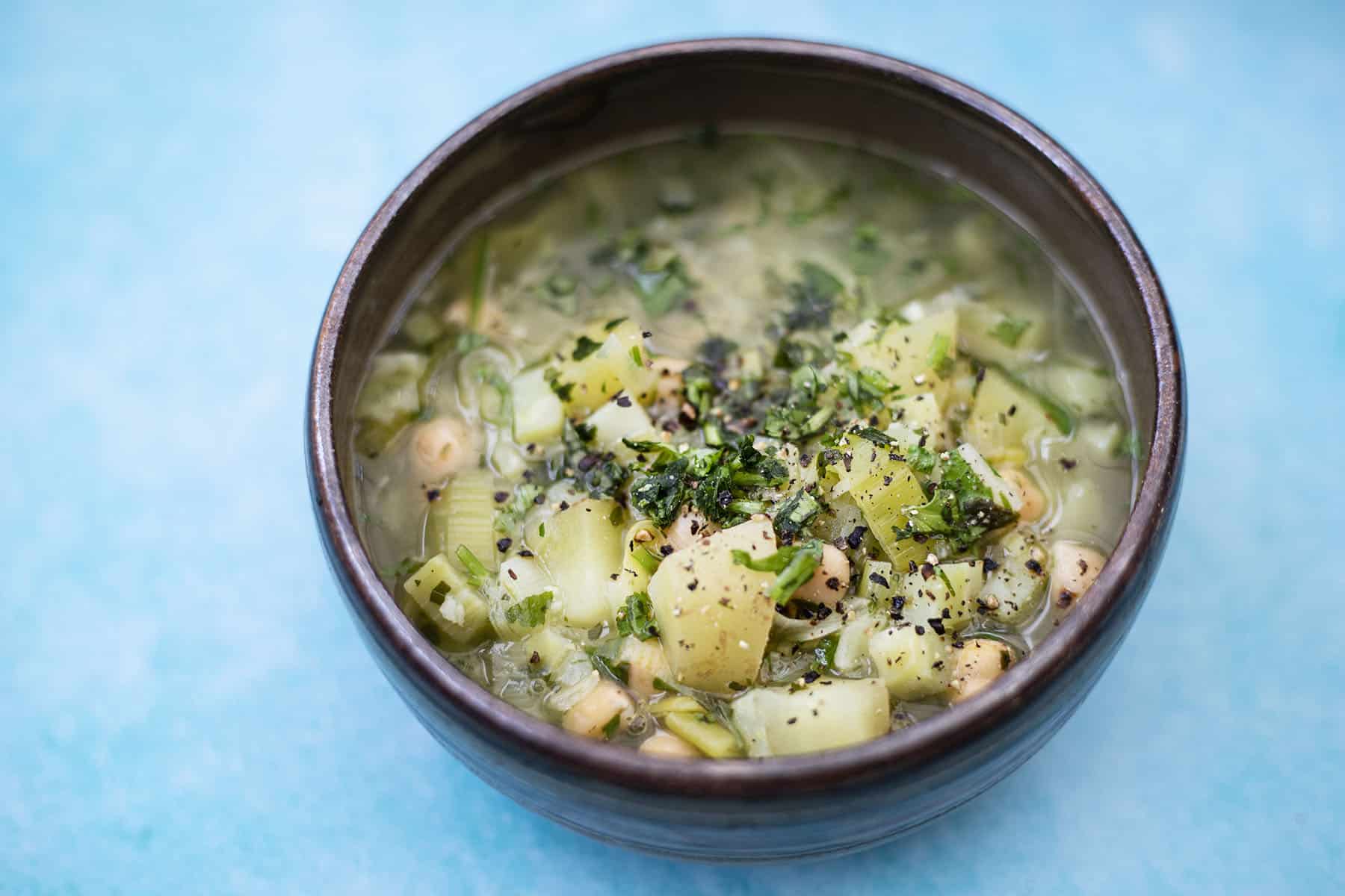 broccoli stalk soup in bowl with herbs
