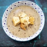 Jerusalem artichoke and chestnut soup in blue and white bowl with croutons